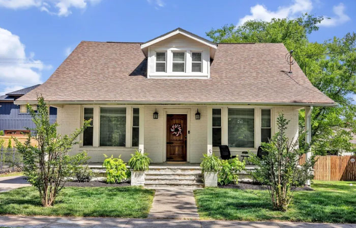A small white brick home with a covered porch in Music Row — one of the best areas to live in Nashville, Tennessee.