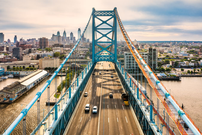 Aerial view of the Ben Franklin Bridge with the Philadelphia city skyline in the distance.