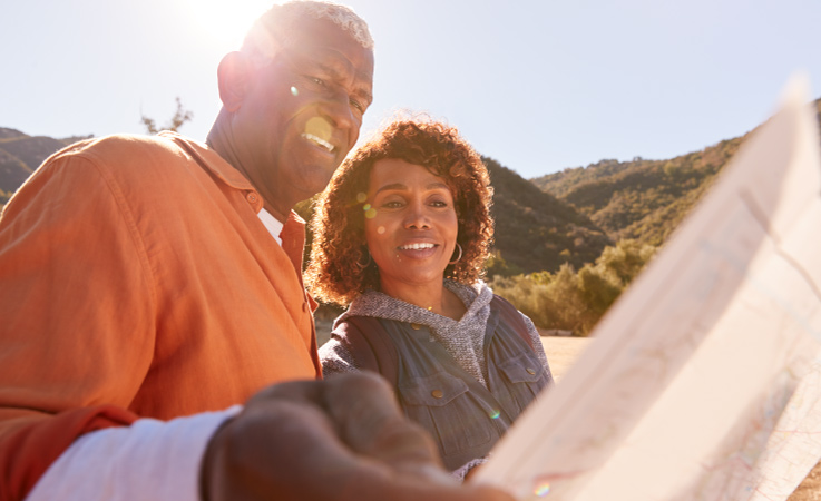 A mature couple is looking at a map together as they consider which of the best states to retire in is right for them