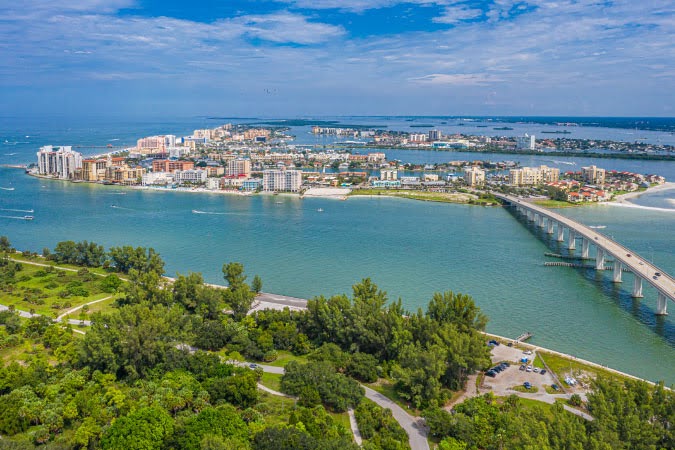 Aerial view of the Florida cities of Clearwater and Clearwater Beach with the Clearwater Memorial Causeway byway connecting the two over blue-green waters.