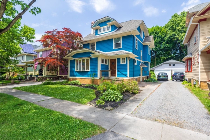 A typical single-family home in Rochester, NY, featuring a brick and siding exterior, bay window, and chimney.