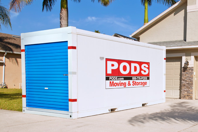 A PODS moving container sits in a residential driveway to be used to store belongings during reconstruction after damage.