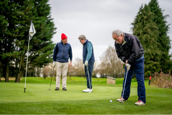 Three mature men are playing golf at one of the best retirement communities in the U.S.