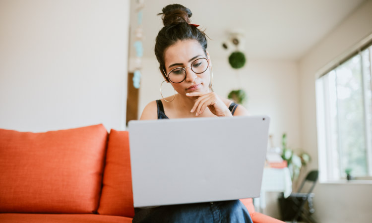 A woman is vetting moving companies online before deciding which one to hire — an important step on any apartment moving checklist.