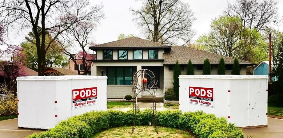 Two PODS moving and storage containers are positioned in a curved driveway with their doors facing the entrance of the house. They’re ready to be easily loaded with moving boxes, furniture, and other things.