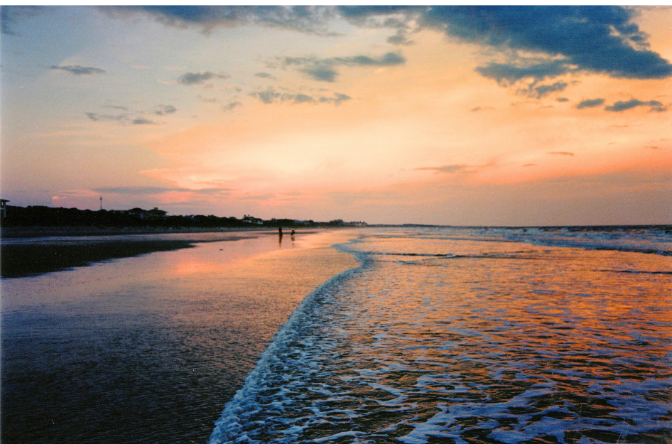 A couple living in Kiawah Island, SC walk along the beach at sunset.