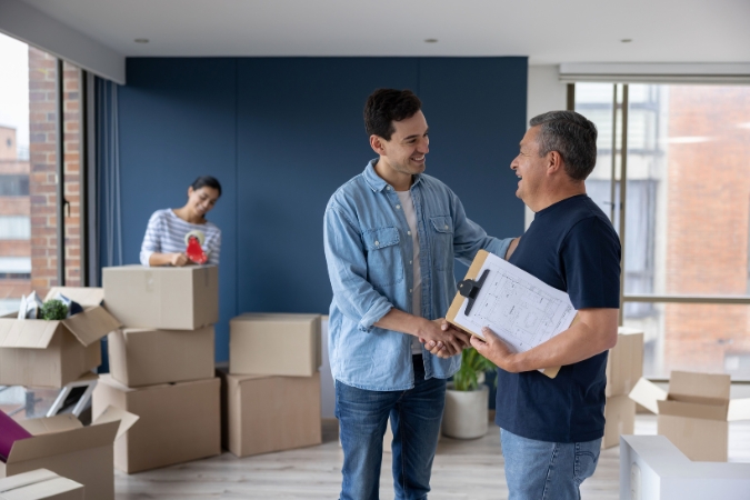 A homeowner is speaking with a professional mover he hired as part of his moving day checklist.