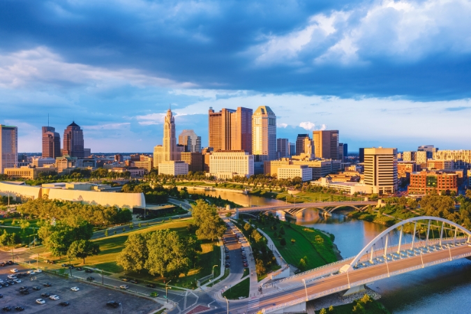 Aerial view of downtown Columbus with the Scioto River glowing at sunset, in Ohio — considered by some to be the best state to buy a house in 2026.