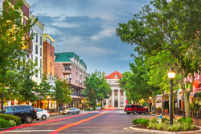 Downtown Gainesville, Florida, at twilight. The blue sky is darkening and the colors of the city seem more vibrant in the dimmer light.