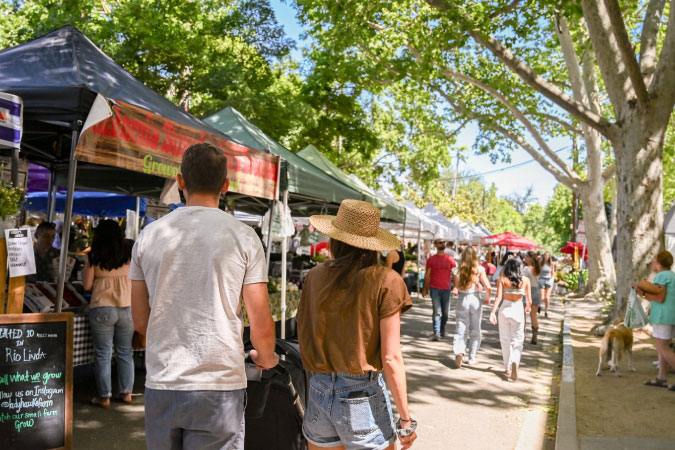 Dozens of locals living in Sacramento browse the stalls at the Midtown Farmers Market in Sacramento, on a sunny day.