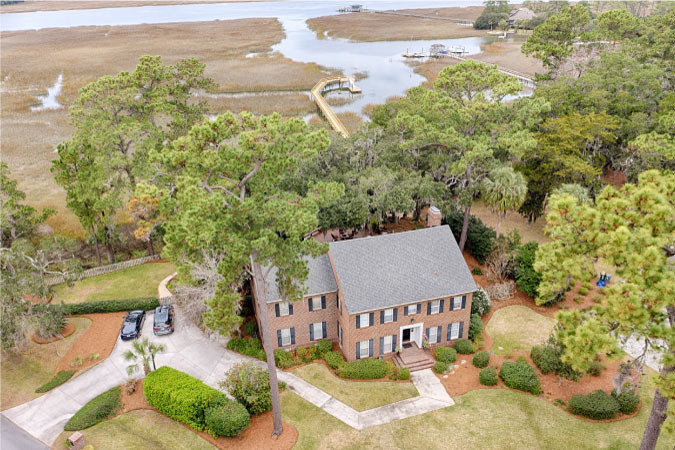 Aerial view of a two-story brick home on Dutch Island in Savannah, Georgia, surrounded by marshland.