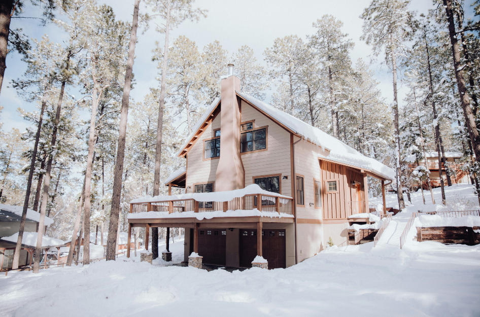 A home in the woods in the snow that has been checked for winter home maitence.