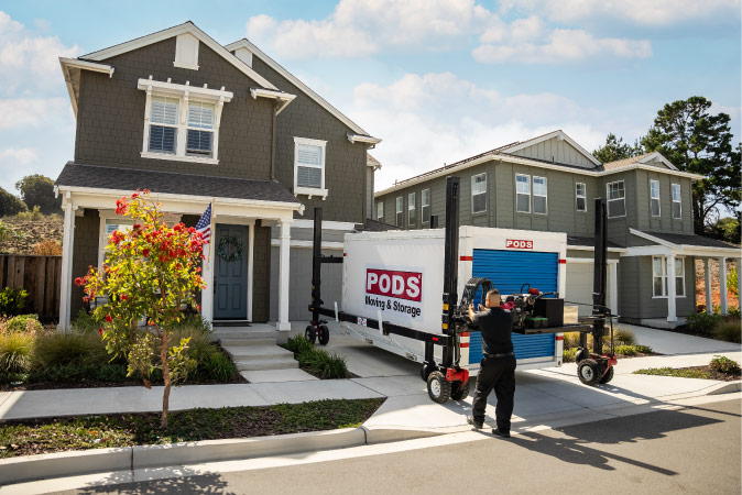 A PODS driver uses PODZILLA to expertly maneuver a PODS portable moving container onto a residential driveway.