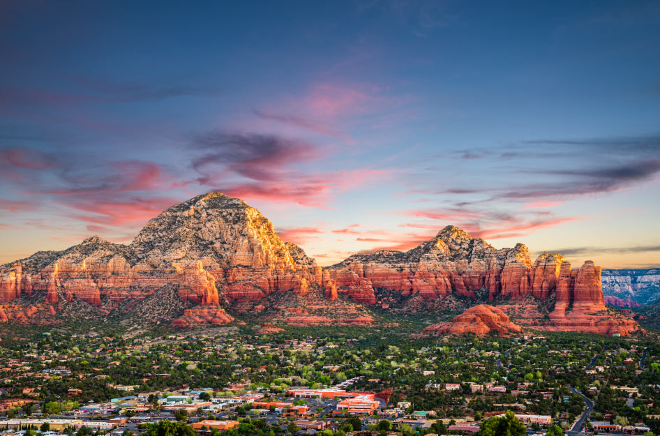 Distant sunset view of Sedona, Arizona, and the stunning mountains behind the city.
