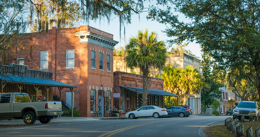 Red brick buildings in Downtown Micanopy, Florida, are speckled with sunlight in the late afternoon