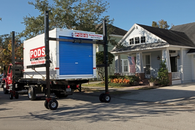 A PODS portable moving container is being delivered to a residential home that meets PODS driveway requirements.