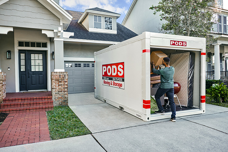 A man loads his final box in his PODS container as he prepares for his move to Galveston.