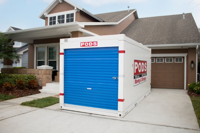 A PODS portable moving container is positioned conveniently in a residential driveway, ready to be loaded up for a long-distance move.