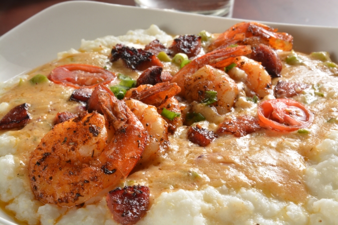 A plate of savory shrimp on top of a bed of grits, a menu item at one of the best restaurants in Greensboro, NC.