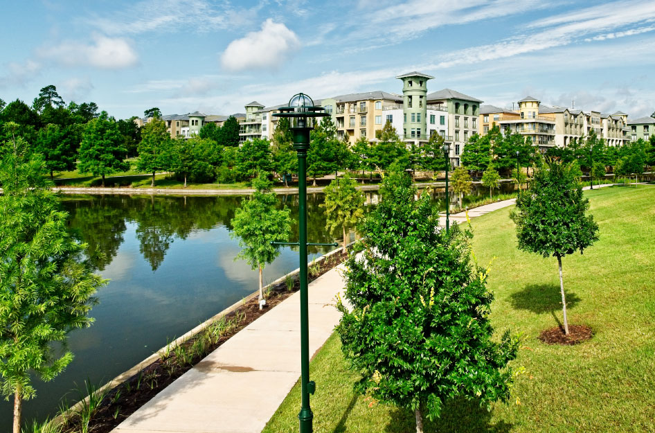 A view of residential buildings in The Woodlands, Texas, and one of the community’s waterways on a sunny summer day.