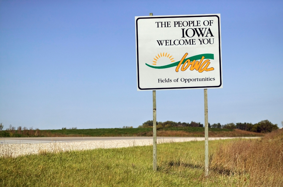 A highway welcome sign reading “The People of Iowa Welcome You” greets newcomers living in Iowa.