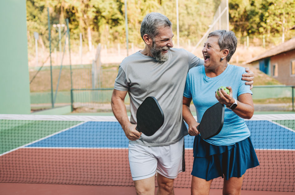 A senior couple is playing pickleball in one of the best retirement communities in the U.S.