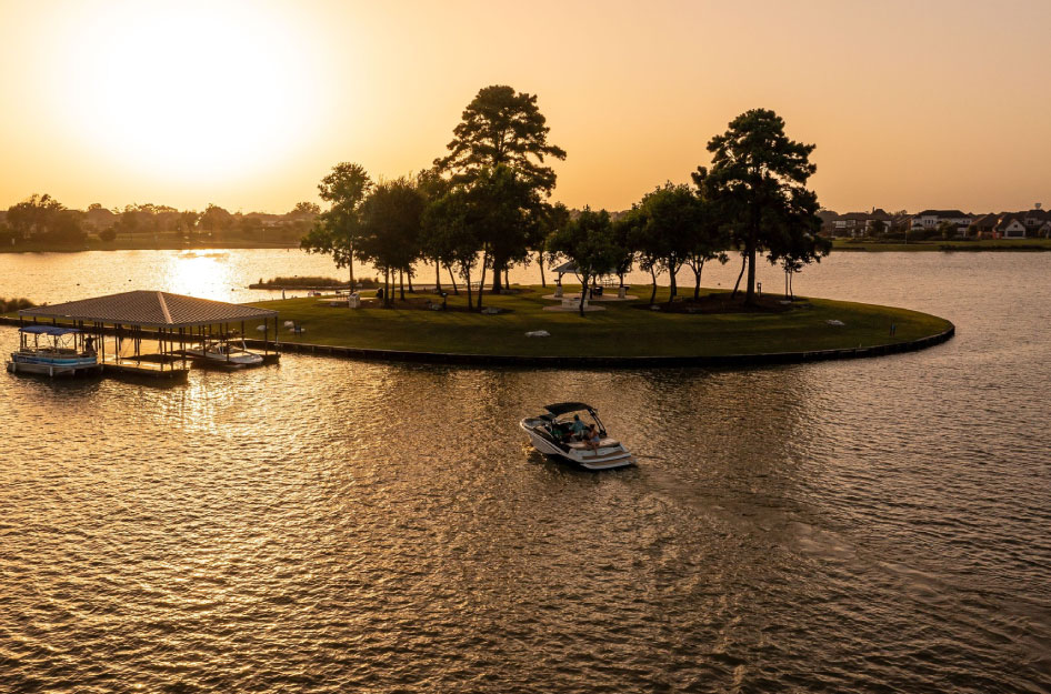 Boaters enjoy dusk out on the water by Puckett Island in the Towne Lake community of Cypress, Texas.