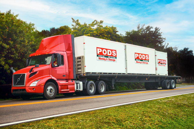 A PODS truck is transporting three portable moving containers long-distance for a family that will soon be living in Rochester, NY.
