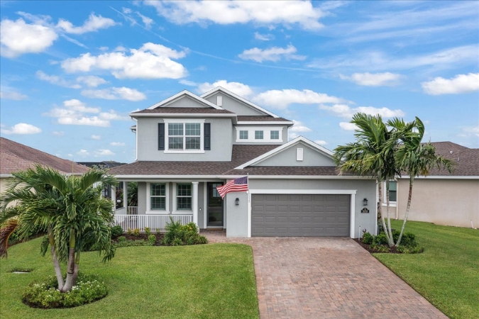 Modern two-story home in Viera, one of the best places to live in Melbourne, FL, featuring a manicured lawn with palm trees and well-designed landscaping.