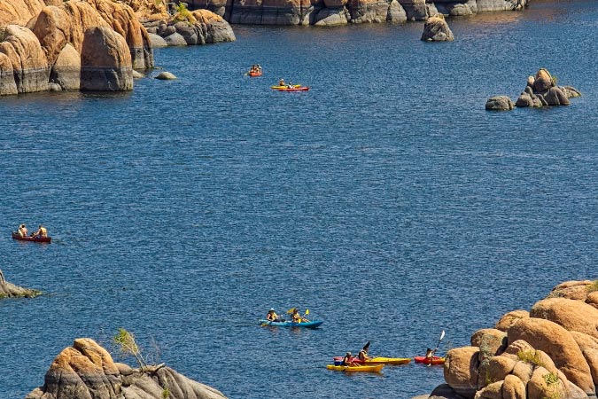  Locals living in Prescott, AZ, enjoy a sunny day kayaking and canoeing out on the water at Watson Lake Park.