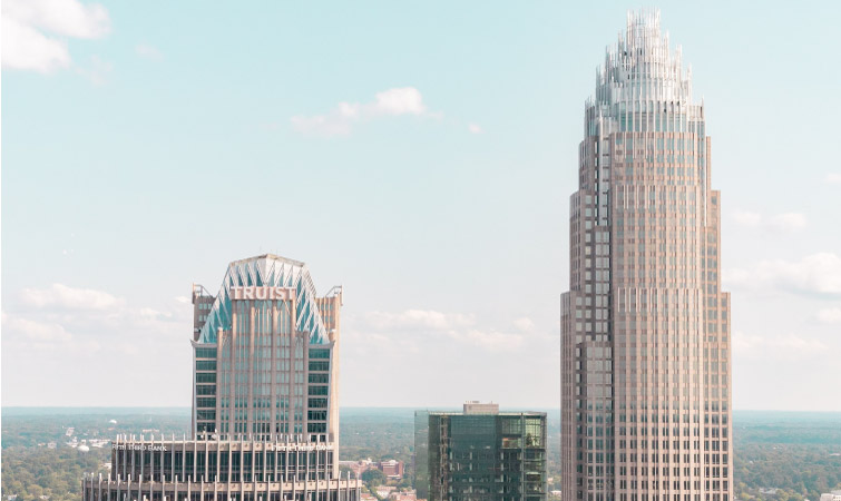A rooftop view of two skyscrapers in Charlotte, NC, including the Bank of America Tower. Is Charlotte, NC, a good place to live? It is if you’re looking to work in the finance industry. 