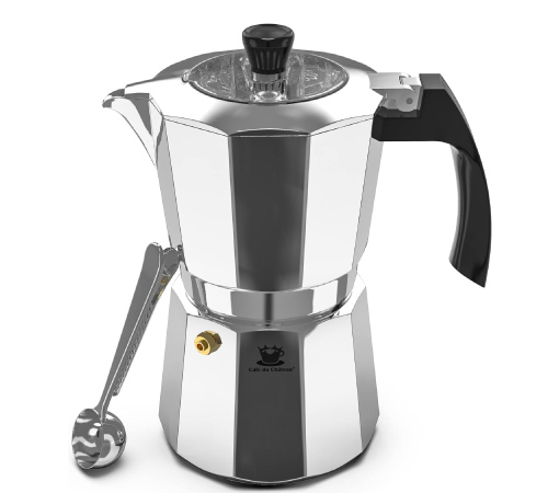 A six-cup stovetop espresso maker on a white counter with a coffee clip spoon leaning against it