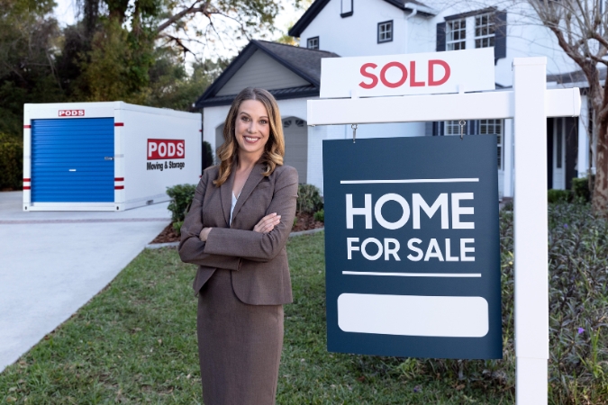 A real estate agent is standing beside a
