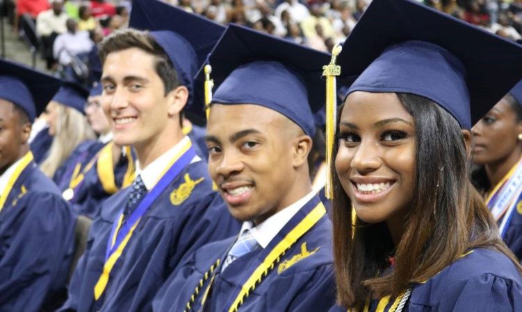 Three graduates of Duval County Public Schools smile for a picture during their graduation ceremony in Jacksonville, Florida
