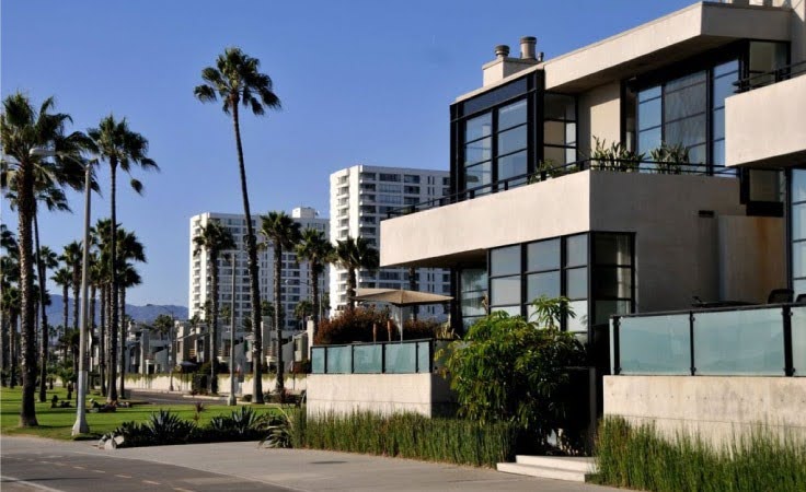 Exterior view of an upscale apartment building in Los Angeles, featuring industrial architecture with concrete and glass elements.