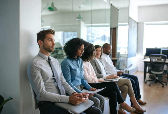 Five professionals are sitting in a line, waiting to be interviewed for a new position.