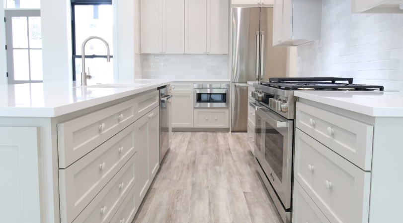 A modern kitchen with white cabinets is equipped with all energy-efficient appliances.
