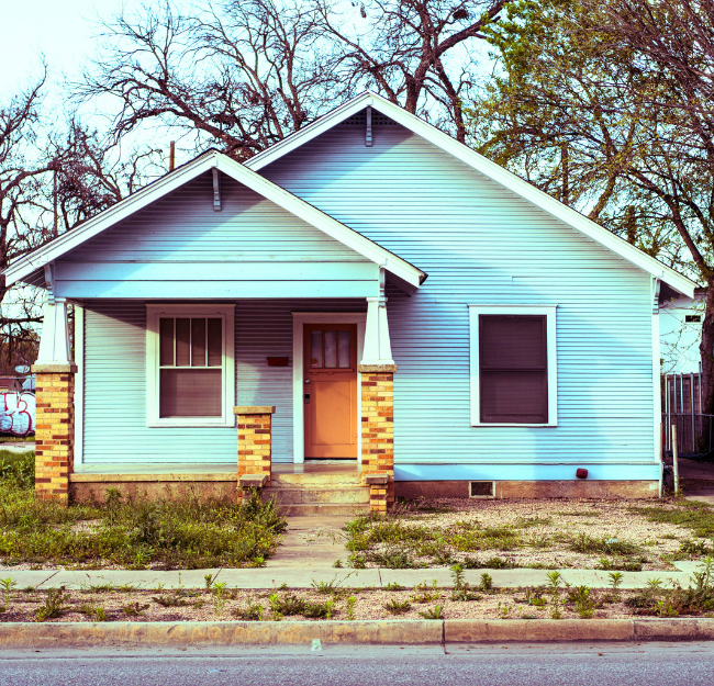A blue house with brick pillars in Rosedale, one of the safest neighborhoods in Austin.