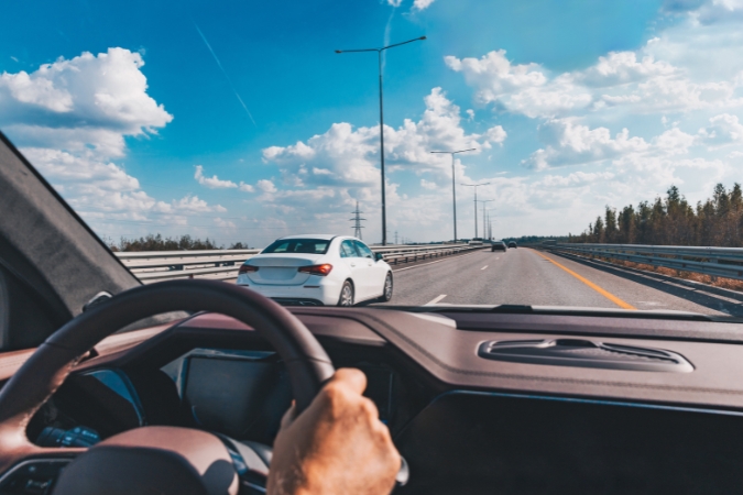 A driver’s seat view of cars traveling along a car-friendly Iowa highway, highlighting everyday life in the state.