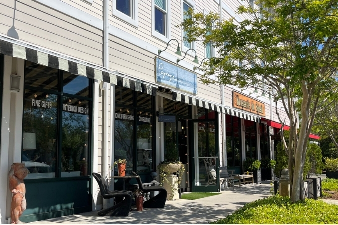 Shops and boutiques at Lumina Station in Wilmington, NC, with sidewalk seating, storefront awnings, and landscaped walkways, reflecting nearby Wilmington neighborhoods.