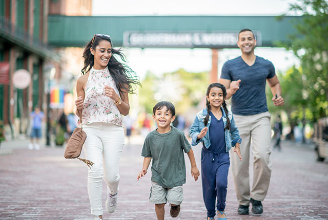 A young family running in a shopping plaza