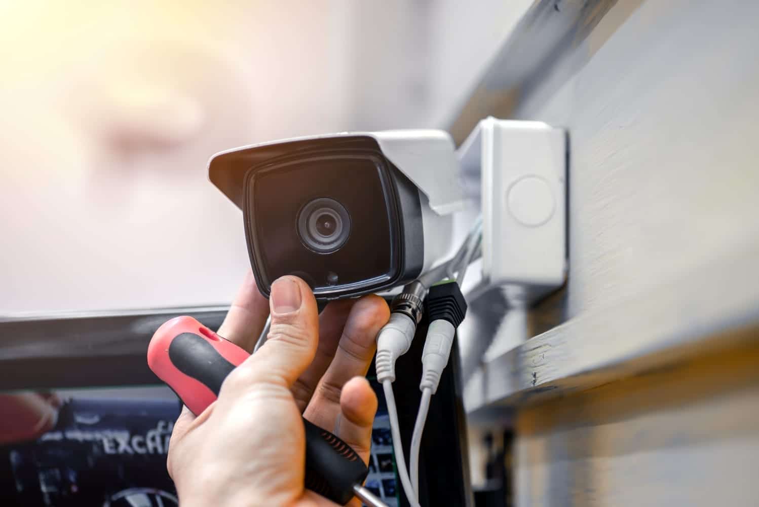 A man installing a home camera system to his home