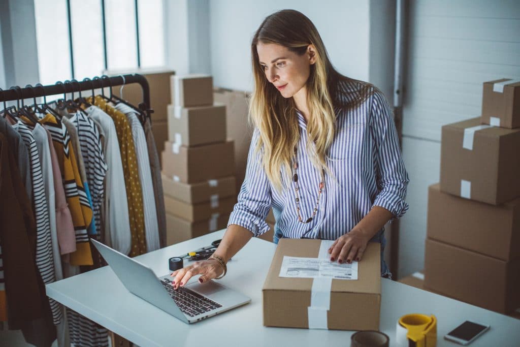 Female employee packing box for delivery to support her company supply chain