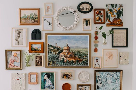 a white wall with different kinds of art hanging on it. 