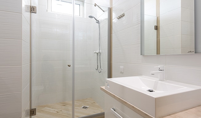 A stripped-down bathroom that showcases its beautiful sealed hardwood flooring