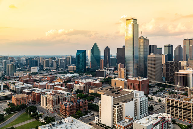 The Dallas Texas skyline during the day. There are buildings of different sizes and skyscrapers throughout the image.