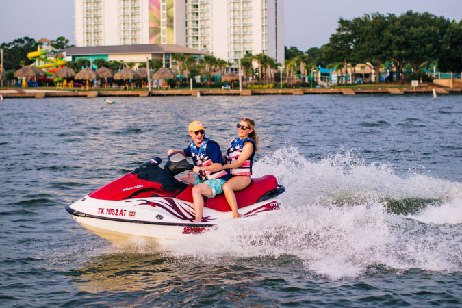 A couple is having fun driving a jet ski on Lake Conroe outside Conroe, Texas.