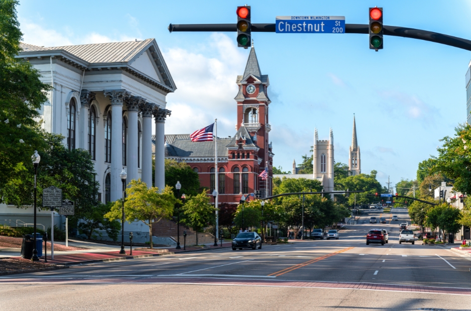 Sunny view down Historic Third Street in Wilmington, North Carolina, featuring government buildings and churches and light traffic traveling through neighborhoods in Wilmington, NC.