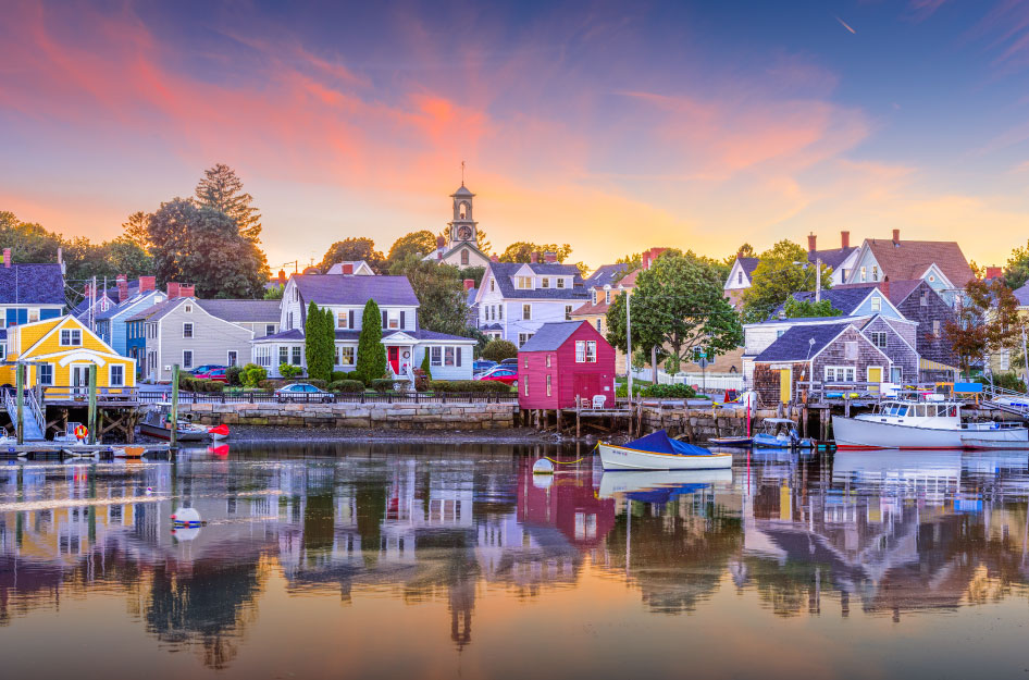 View of quaint homes on the waterfront in Portsmouth, New Hampshire. Portsmouth features a classic New England look, which is almost perfectly reflected off the calm waters.