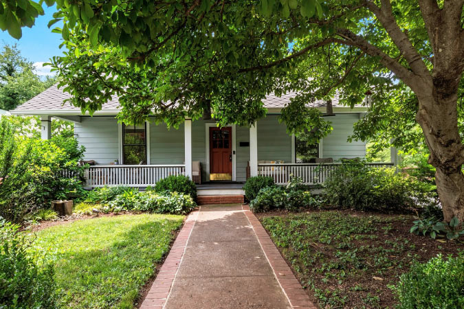 A historic Craftsman bungalow in West Salem — one of the best Winston-Salem neighborhoods — featuring a shady front yard and a covered porch.